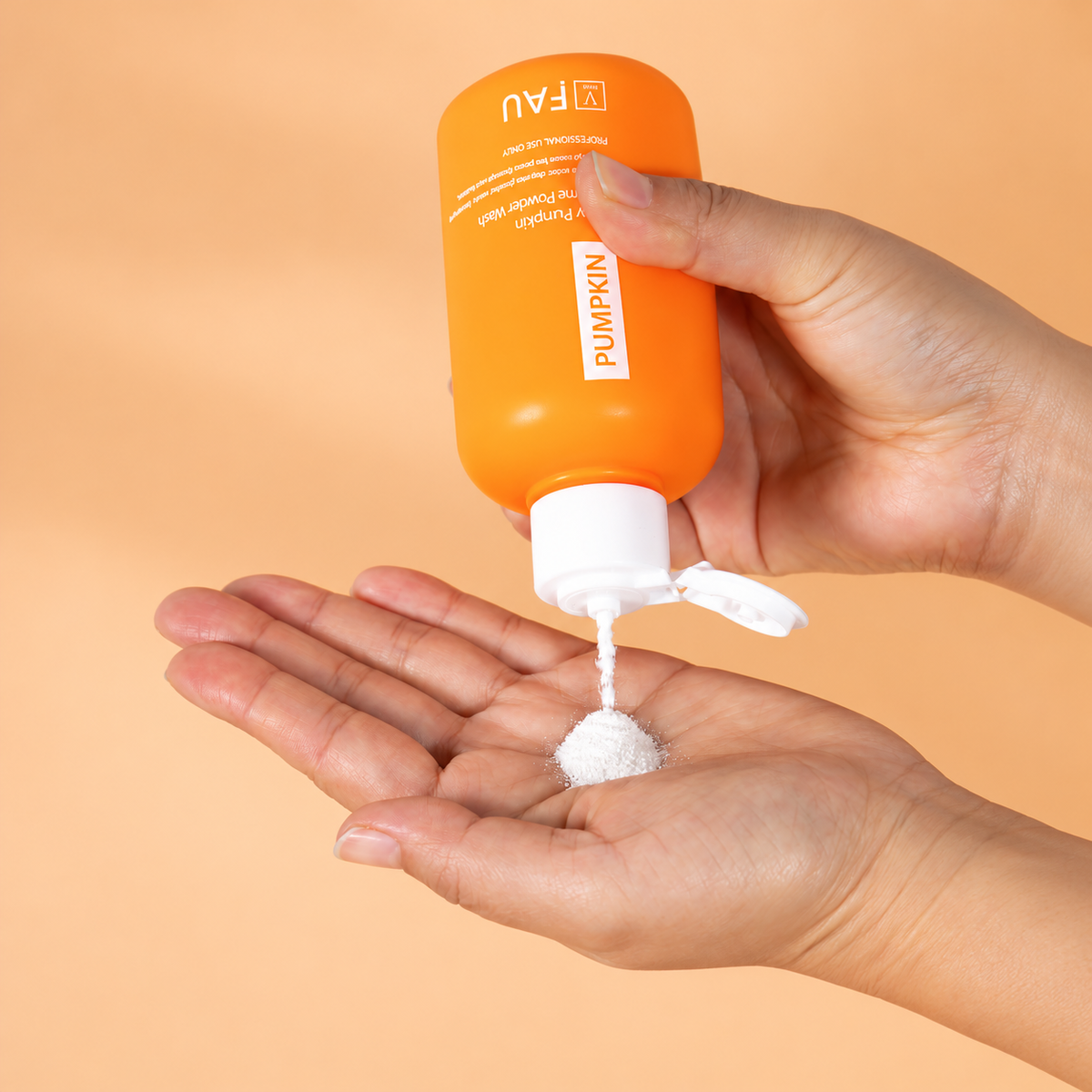 FAU Shiny Pumpkin Enzyme Powder Wash being dispensed into a palm.